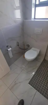 a bathroom with a white toilet in a room at Cosy Cove in Grassy Park
