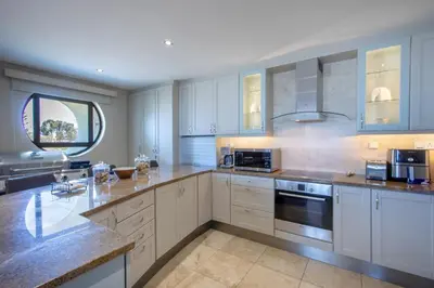 a large kitchen with white cabinets and a window at Atlantica202 in Strand