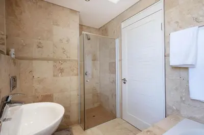 a bathroom with a shower and a sink and a toilet at Atlantica202 in Strand