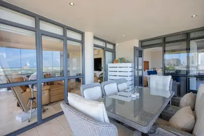 a living room with a glass table and chairs at Atlantica202 in Strand