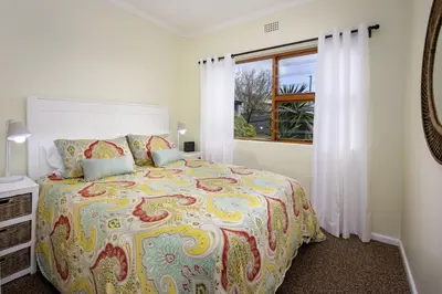 a bedroom with a large bed and a window at Fisherhaven in Hermanus
