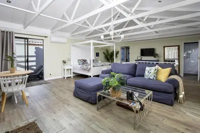 a living room with a blue couch and a table at Fisherhaven in Hermanus