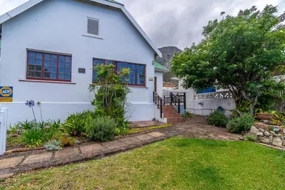 a white house with a yard in front of it at 162 on 6th in Hermanus