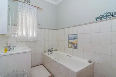 a white bathroom with a tub and a sink at 162 on 6th in Hermanus