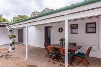a patio with a table and chairs and a building at 162 on 6th in Hermanus