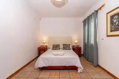 a bedroom with a bed with two night stands and two lamps at 162 on 6th in Hermanus