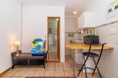 a kitchen with a counter and a chair in a room at 162 on 6th in Hermanus