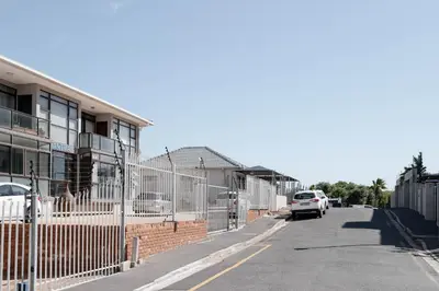 a street with a fence next to a building at Seabreeze at the Beach in Strand