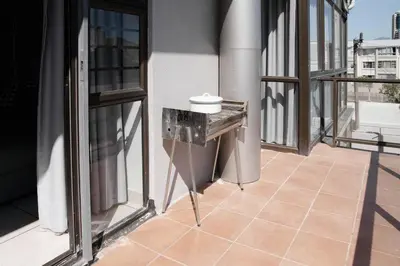 a balcony with a table on the side of a building at Seabreeze at the Beach in Strand