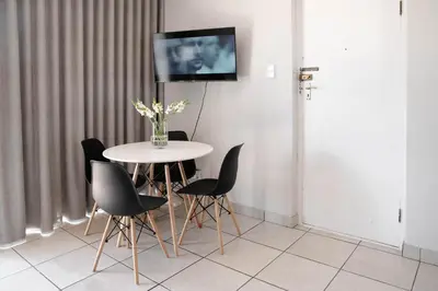 a table and chairs with a tv on a wall at Seabreeze at the Beach in Strand