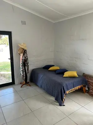 a bedroom with a bed and a person wearing a hat at Seewind in Hermanus