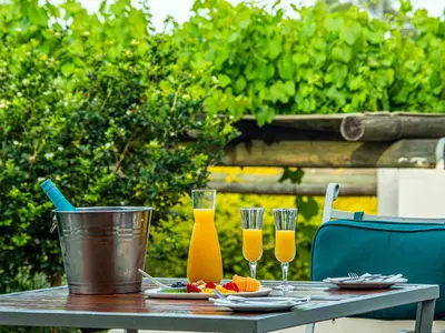 a wooden table with two glasses of orange juice at Diemersfontein Wine & Country Estate in Wellington