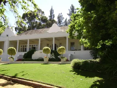 a white house with a lawn in front of it at Diemersfontein Wine & Country Estate in Wellington