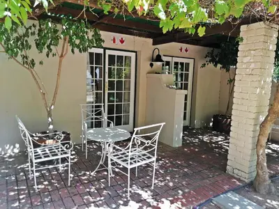 a patio with a table and chairs and a refrigerator at Diemersfontein Wine & Country Estate in Wellington