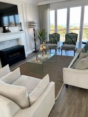 a living room with white furniture and a fireplace at Whale Coast Luxury in Bettyʼs Bay