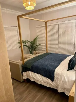 a bedroom with a large bed with a blue blanket at Whale Coast Luxury in Bettyʼs Bay