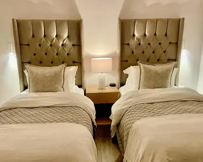 a hotel room with two beds and a lamp at Whale Coast Luxury in Bettyʼs Bay