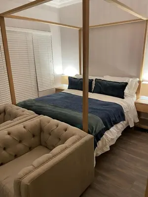 a bedroom with a canopy bed and a couch at Whale Coast Luxury in Bettyʼs Bay