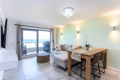 a living room with a table and a couch at Sea Spray B303 by CTHA in Cape Town