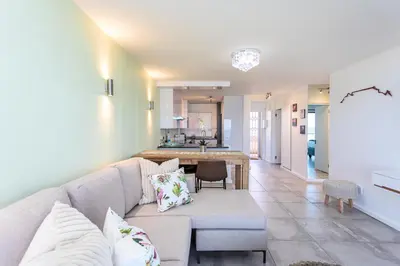 a living room with a couch and a kitchen at Sea Spray B303 by CTHA in Cape Town