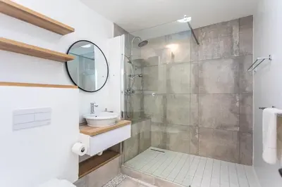 a bathroom with a shower and a sink and a mirror at Sea Spray B303 by CTHA in Cape Town