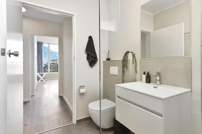 a white bathroom with a toilet and a sink at ZenDen Destinations' Seaside Sanctuary Suite in Strand