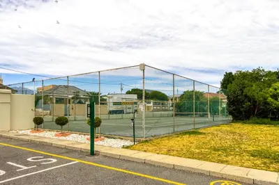 a tennis court with a net on a court at ZenDen Destinations' Seaside Sanctuary Suite in Strand