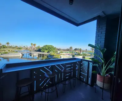 a view from the balcony of a bar with stools at 308 Bridgewater One - Two Bedroom Apartment with Park Views in Cape Town