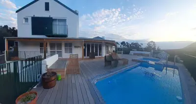 a house with a swimming pool in front of a house at 3 Jongens Villa in Voëlklip