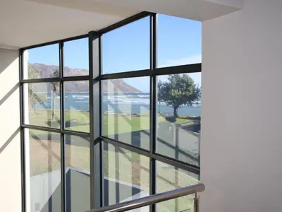 a room with windows looking out at the water at Misty Mountain in Strand