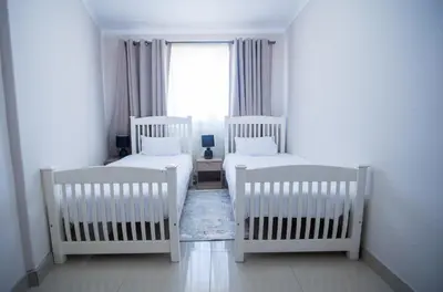 three white cribs in a room with a window at Cape Dreamland in Cape Town