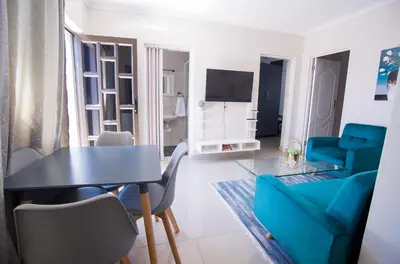 a living room with a table and a blue couch at Cape Dreamland in Cape Town