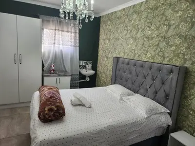a bedroom with a bed with a dog laying on it at Tia Maria bachelor apartment in Cape Town
