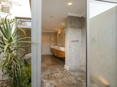 a bathroom with a shower and a sink and a tub at Stellenbosch Luxury Apartments in Stellenbosch