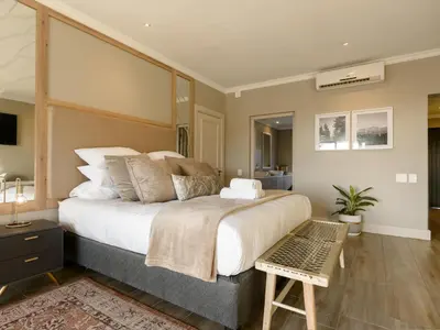 a bedroom with a large bed with a large headboard at Stellenbosch Luxury Apartments in Stellenbosch