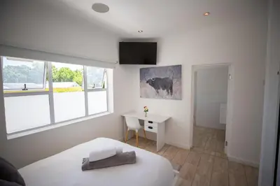 a bedroom with a bed and a desk and window at theLAB Luxury Backpackers in Franschhoek