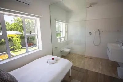 a bathroom with a bed and a shower and a toilet at theLAB Luxury Backpackers in Franschhoek
