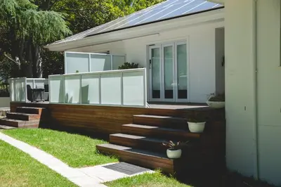 a house with glass doors and stairs in a yard at theLAB Luxury Backpackers in Franschhoek