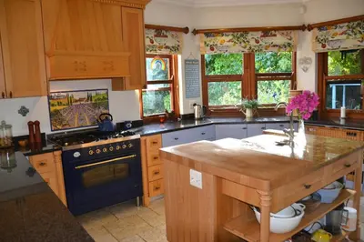 a kitchen with wooden cabinets and a blue stove top oven at Lovely Family Home in the Winelands in Cape Town