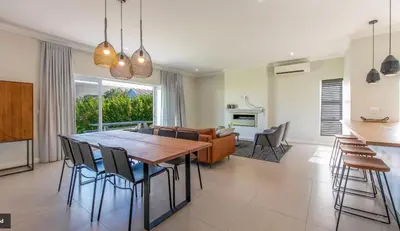 a kitchen and living room with a wooden table and chairs at Val de Vie in Simondium