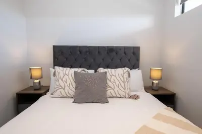 a bedroom with a large white bed with two lamps at Burmeister 302 - Beach Front Views with Onsite Parking in Cape Town
