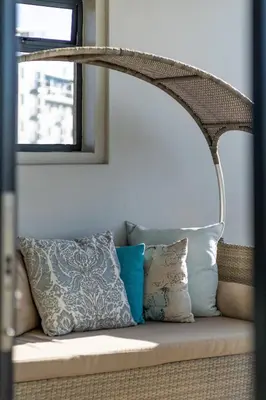 a couch with pillows and a lamp on it at Skyline Serenity - Knightsbridge in Cape Town