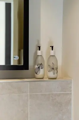 two white vases sitting on a shelf in a bathroom at Skyline Serenity - Knightsbridge in Cape Town