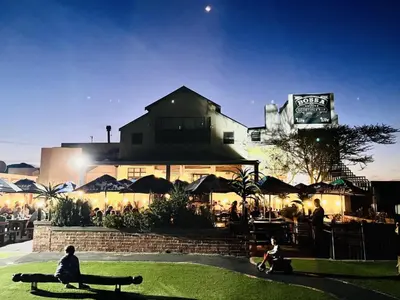 a person sitting on a bench in front of a building at Budapest Boutique Hotel in Edgemead