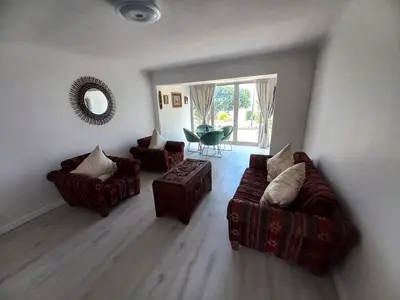 a living room with two couches and a mirror at Whale Rock Estate Four 1 in Hermanus