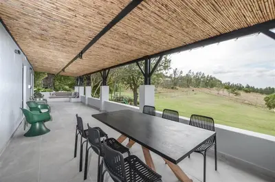 a table and chairs on a patio with a view at 4 Bedroom Farm House in Brackenfell