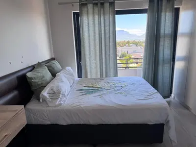 a bedroom with a bed and a large window at Protea house in Cape Town