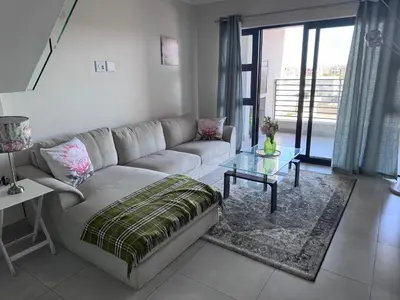 a living room with a couch and a glass table at Protea house in Cape Town