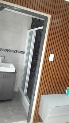 a bathroom with a shower and a sink and a mirror at Sisonke Guest House in Cape Town