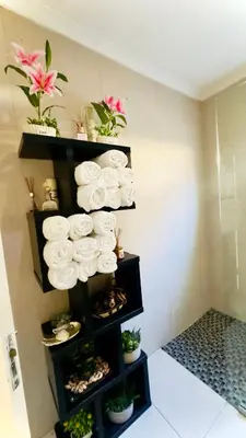 a stack of towels on a shelf with plants at Luxury 2bedrooms house in Cape Town